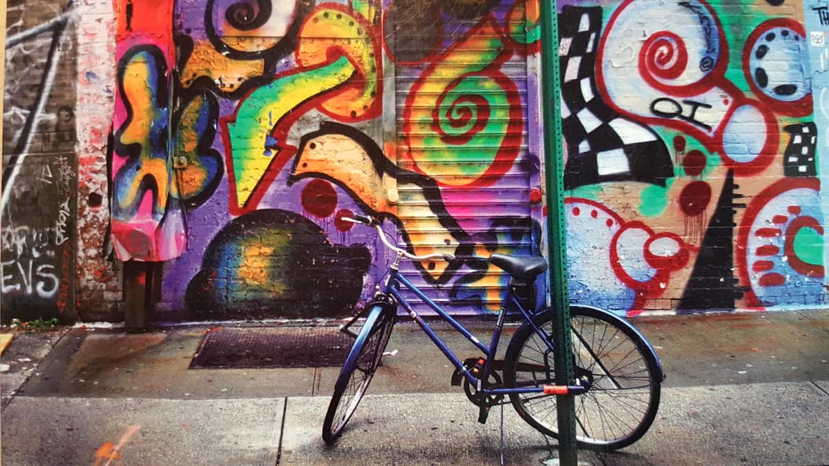 bike parked in front of wall with graffitti
