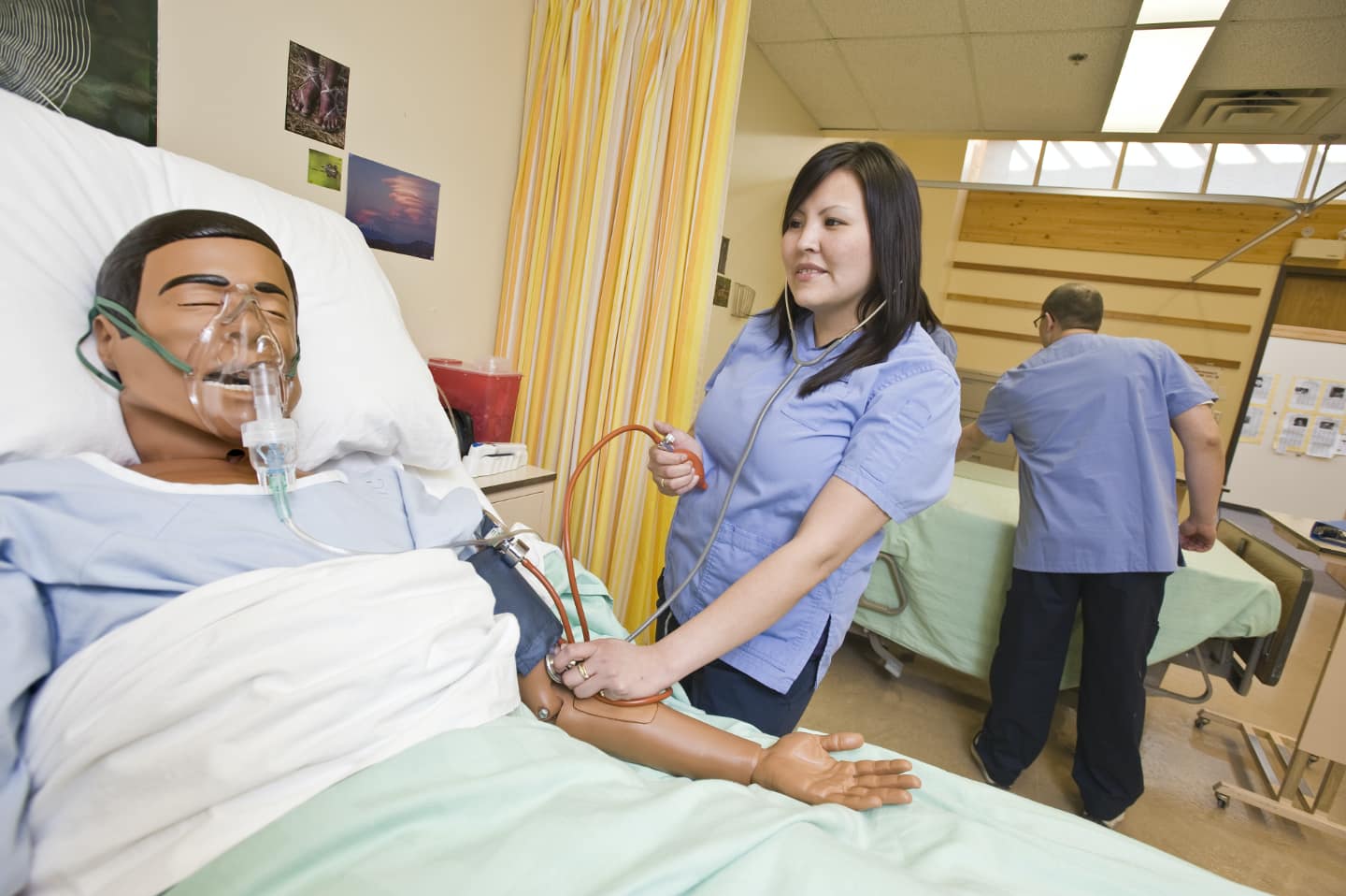 Nursing student checking blood pressure of a patient