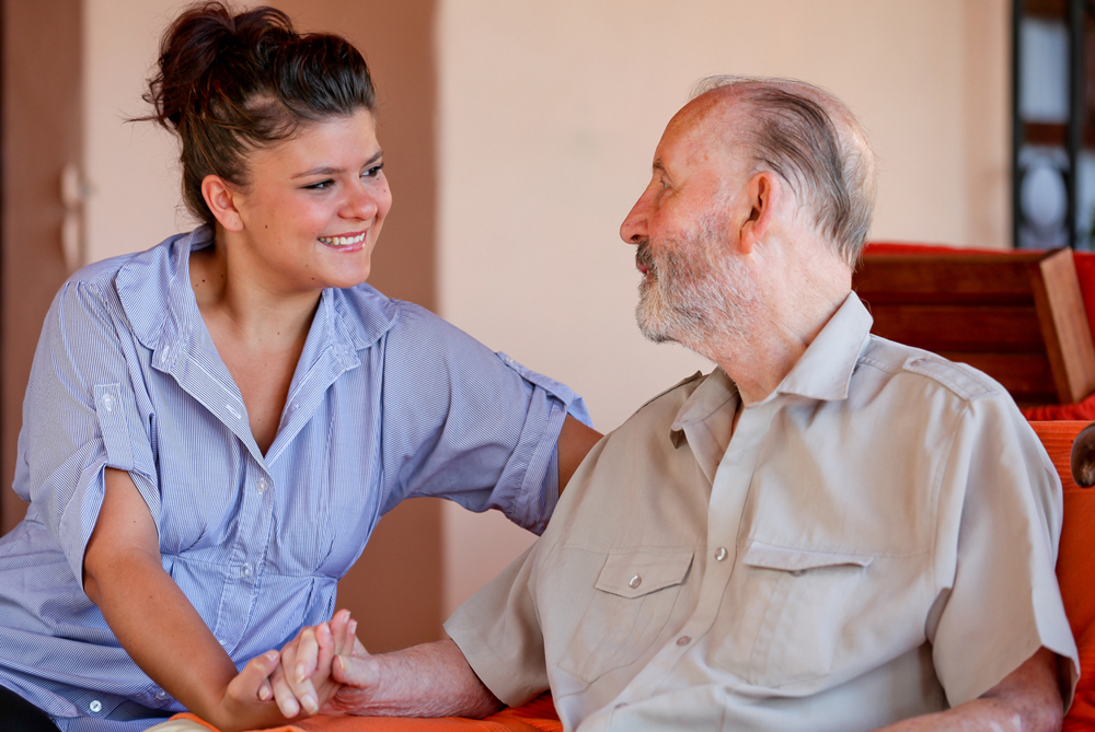 Health Care Assistant engaged in conversation with elderly man