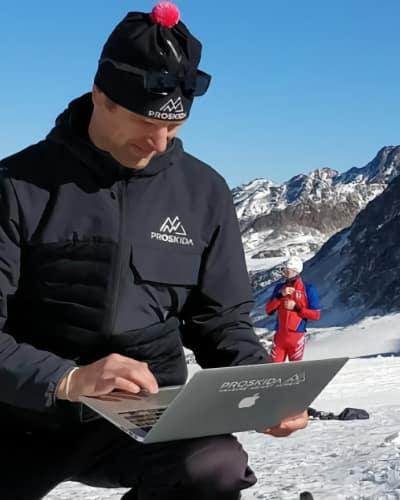 Man using a laptop outside in a snow-covered landscape